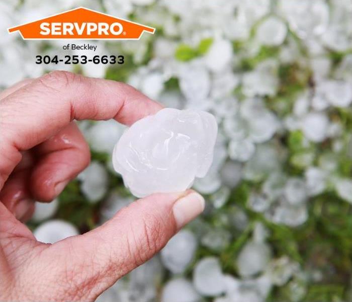 A person holds a one-inch-in-diameter hailstone from a severe thunderstorm. 