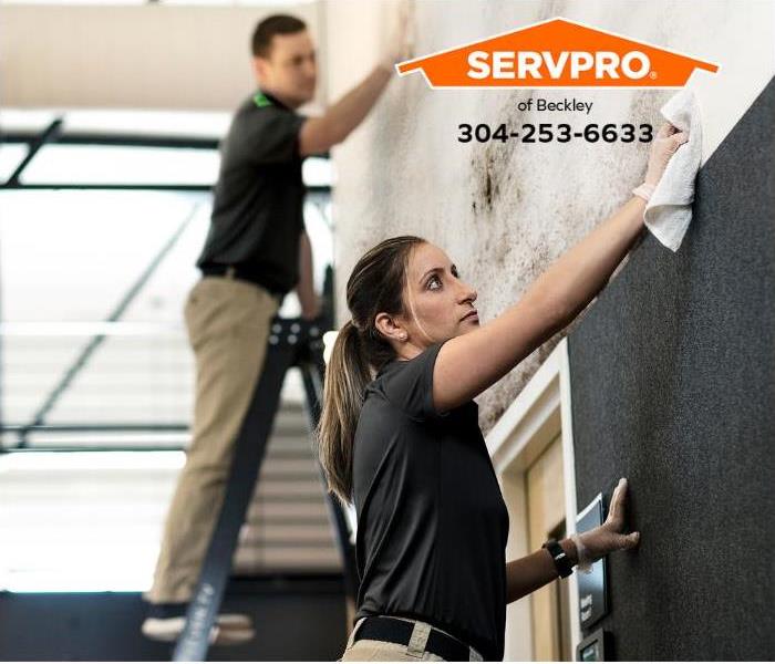 SERVPRO technicians remove soot from a wall in an office. 
