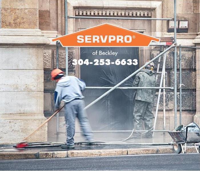 A crew is cleaning the outside of a building.